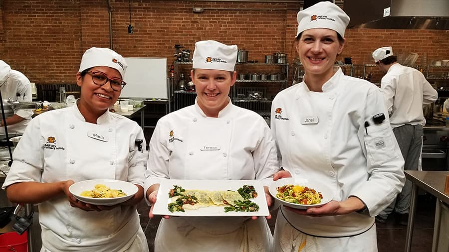 Photo of Park City Culinary Institute students presenting the dishes they've prepared.