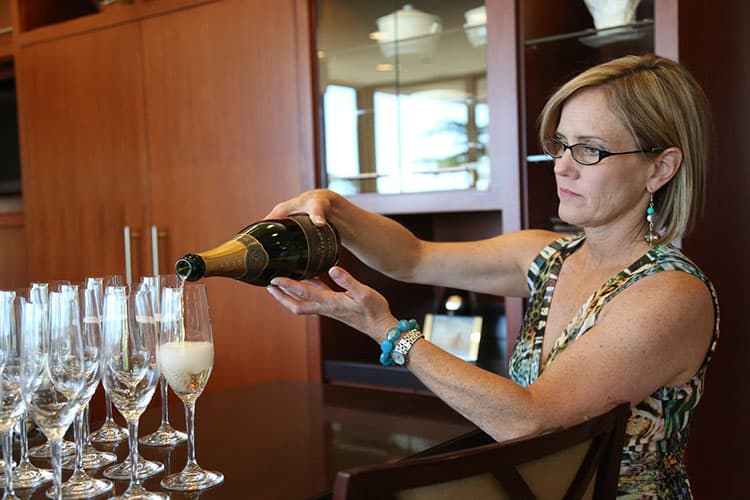 A Park City Culinary Institute hostess pouring champagne at a catered event.