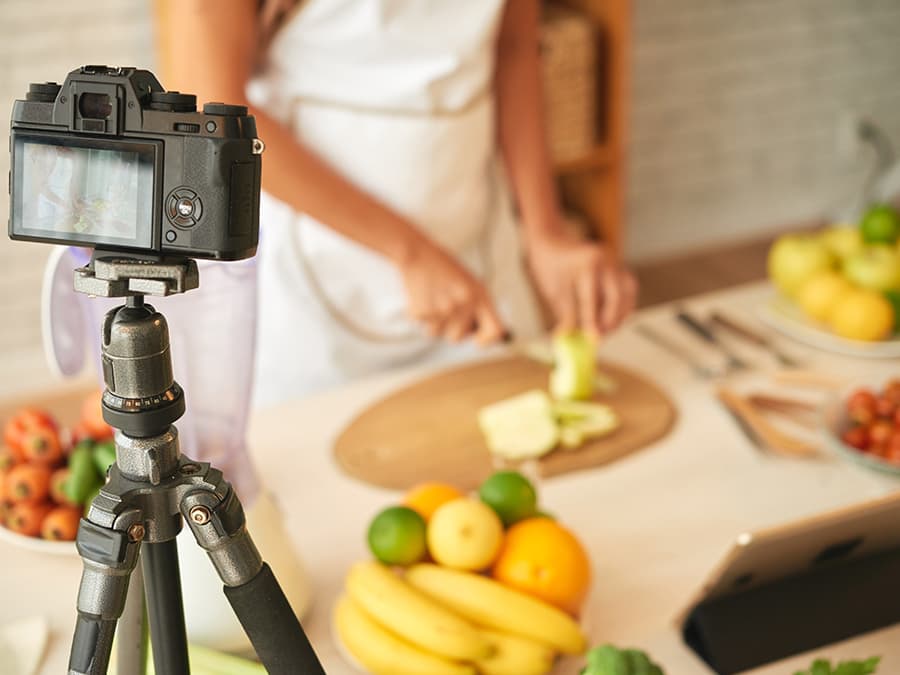 Online student filming herself chopping vegetables.