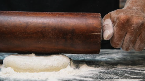 Person Using Brown Wooden Rolling Pin